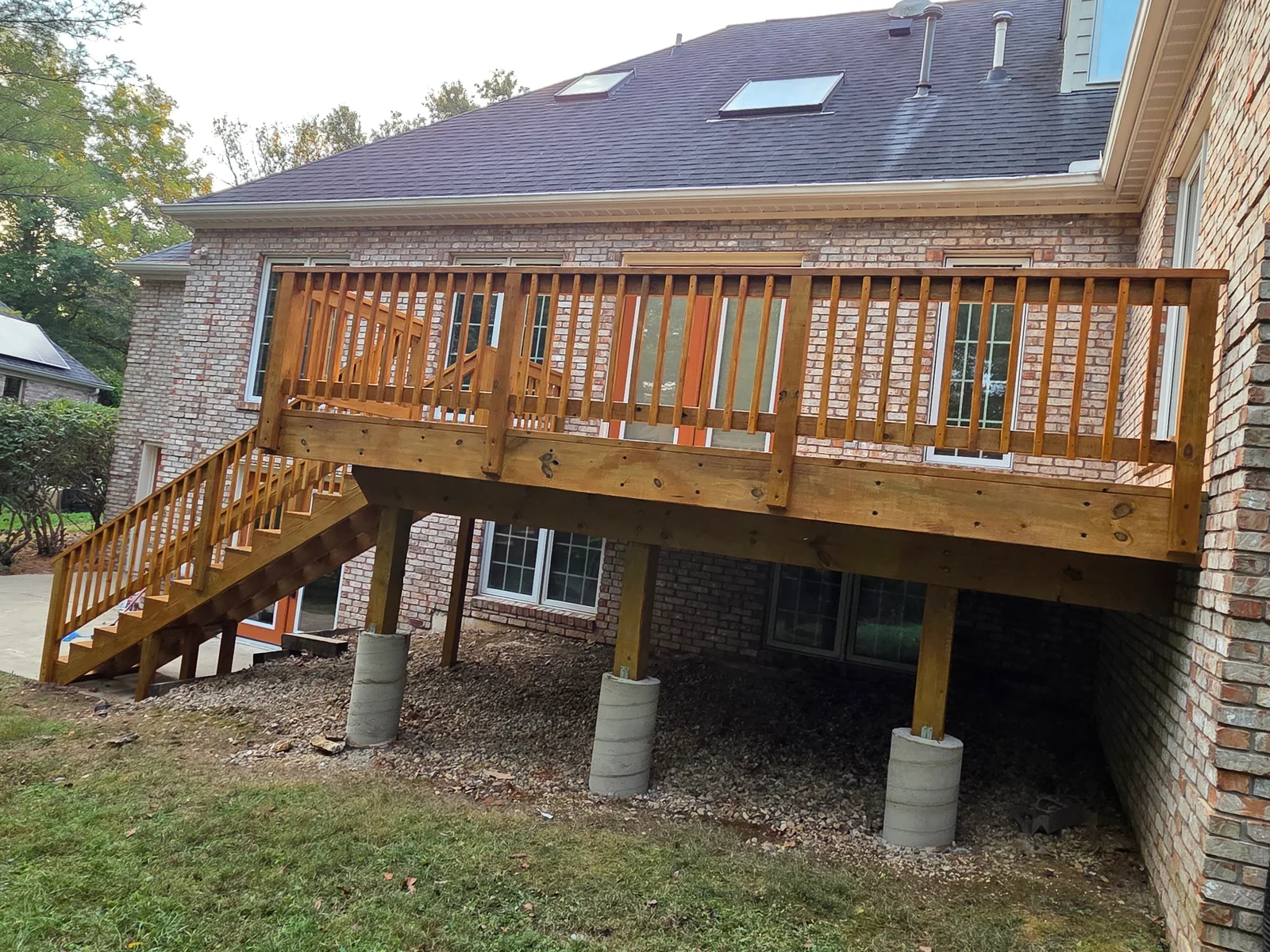 Custom two-level composite deck with spindle railings and staircase built by BEW Construction Inc in Indianapolis, IN