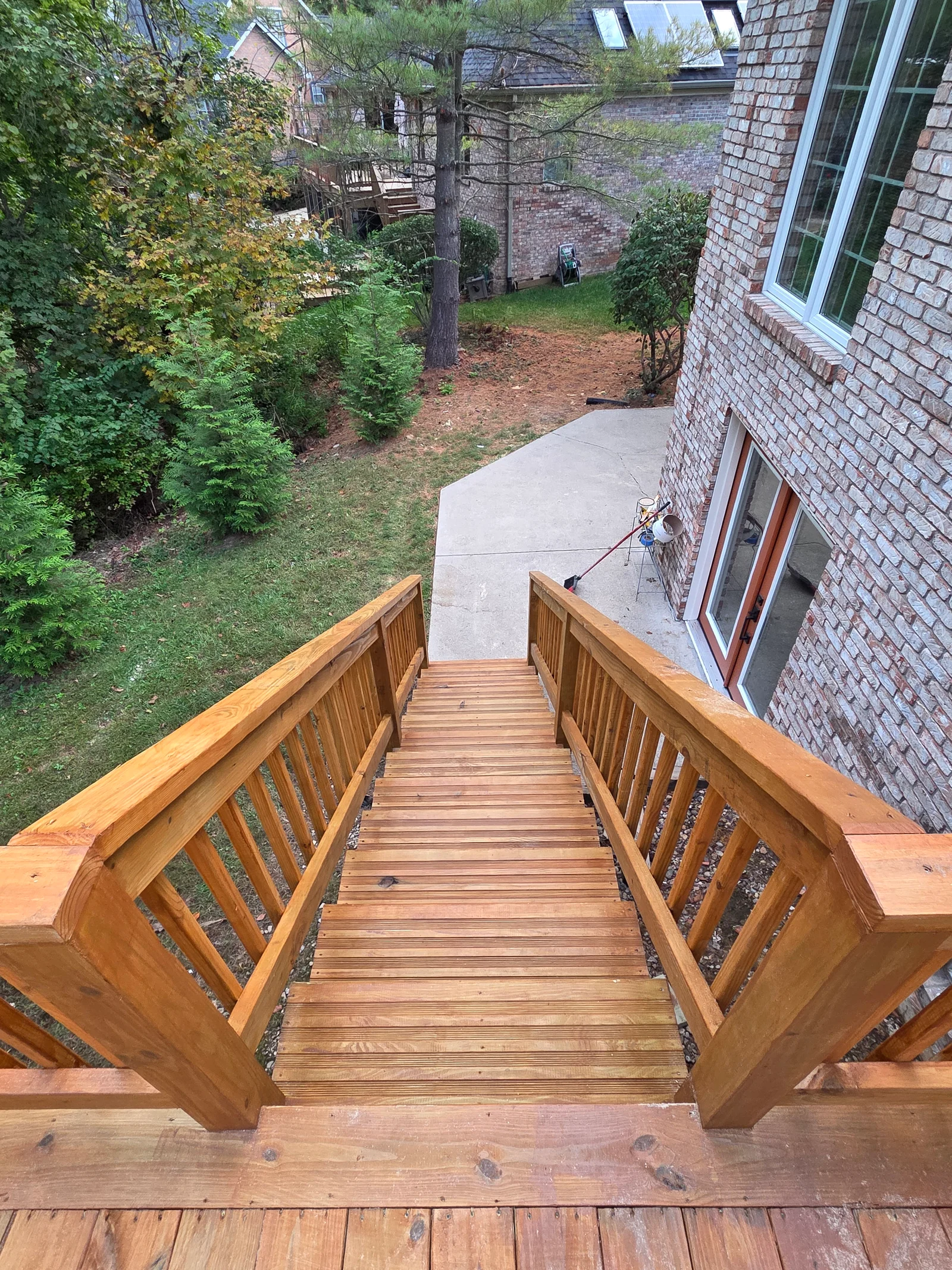 Multi-level wood deck with full staircase and railings integrated with brick home in Noblesville, IN