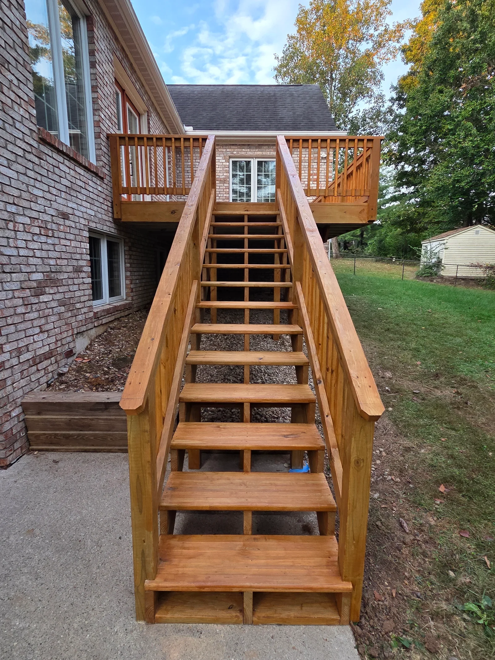Elevated wood deck with dual platforms, central staircase, and spindle railings built in Carmel, IN