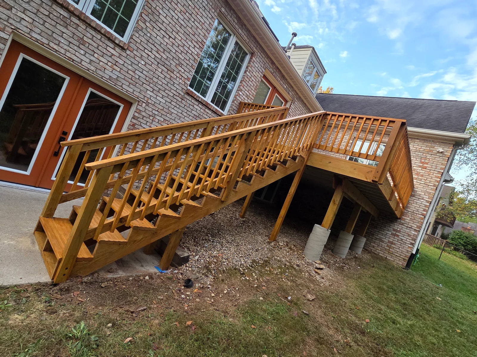 Two-tier wood deck with railings and covered understructure on concrete posts in Indianapolis, IN